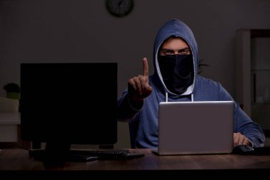 Erkek bilgisayar korsanı, güvenlik duvarını geç saatlerde hackliyor.