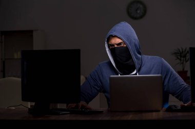 Erkek bilgisayar korsanı, güvenlik duvarını geç saatlerde hackliyor.