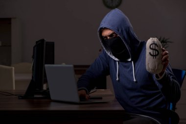 Erkek bilgisayar korsanı, güvenlik duvarını geç saatlerde hackliyor.