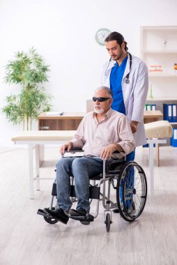 Yaşlı kör adam genç erkek doktoru ziyaret ediyor.