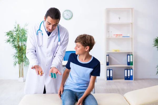 Joven médico examinando a un niño en la clínica —  Fotos de Stock