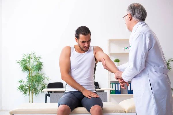 Paciente masculino joven que visita al médico experimentado — Foto de Stock