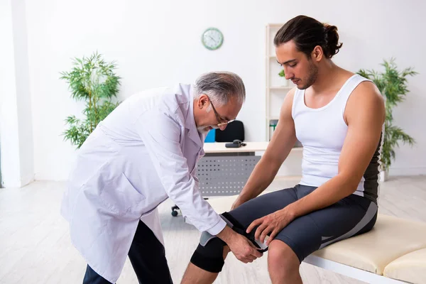 Jovem paciente do sexo masculino visitando médico experiente — Fotografia de Stock