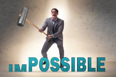 Businessman hitting the word impossible with hammer clipart
