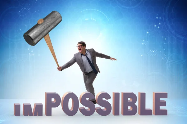 Businessman hitting the word impossible with hammer — Stock Photo, Image