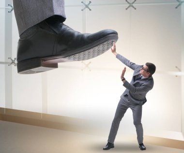 Kötü patron iş konseptinde çalışanın üzerine basıyor.