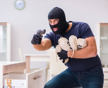Soyguncu kar maskesi takıp değerli şeyler çalıyor.