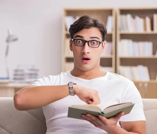 Man reading book sitting in couch sofa — Stock Photo, Image