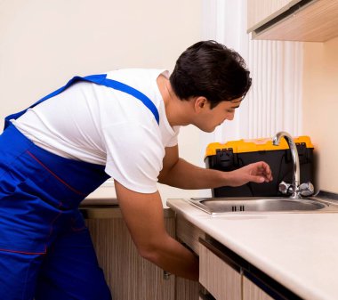 Mutfakta çalışan genç tamirci.