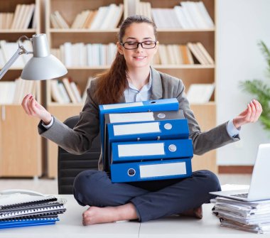 İş kadını ofiste meditasyon yapıyor.