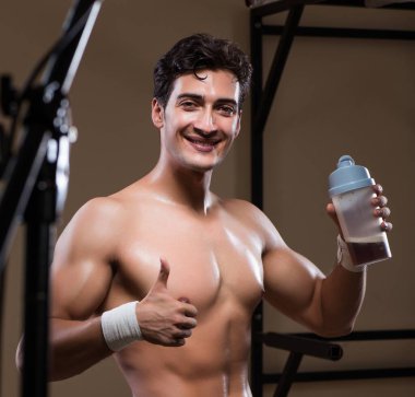 Spor salonunda besin takviyesi olan bir adam.