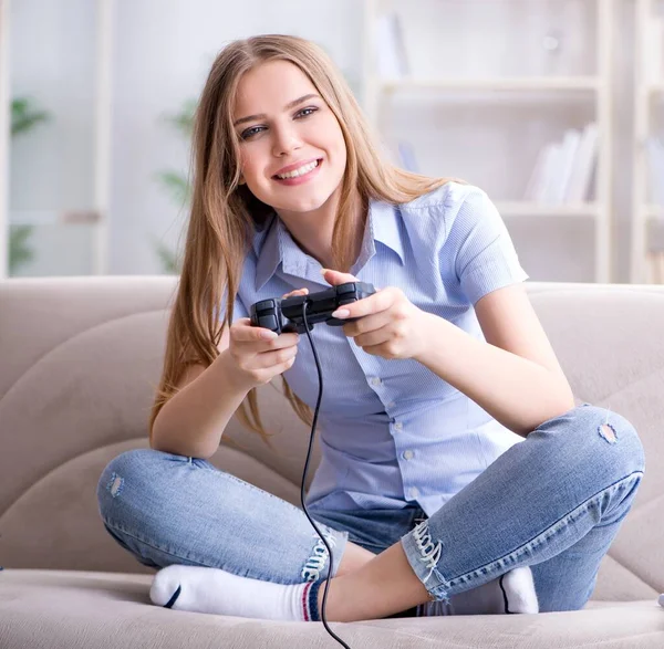 Jonge vrouwelijke student speelt spelletjes thuis — Stockfoto