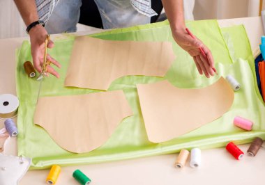 Atölyesinde çalışan yakışıklı bir terzi.