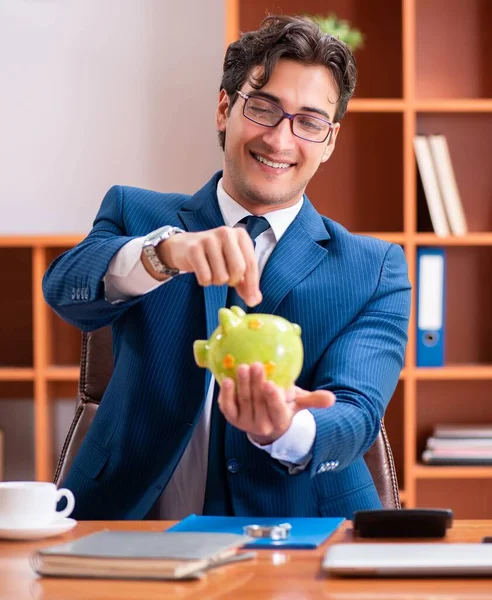 Genç yakışıklı işadamı ofiste çalışıyor.