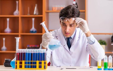 Genç yakışıklı biyokimyacı laboratuvarda çalışıyor.