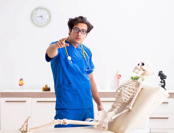 Doutor engraçado com esqueleto no hospital — Fotografia de Stock