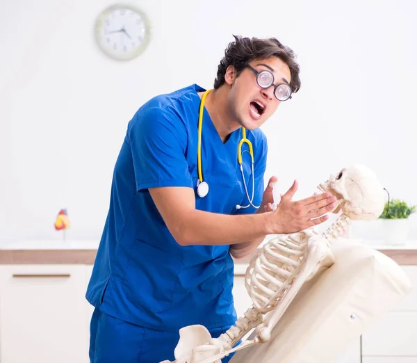 Médico divertido con esqueleto en el hospital — Foto de Stock