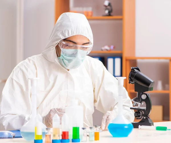 Jovem bioquímico vestindo roupa protetora trabalhando no laboratório — Fotografia de Stock