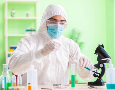 Laboratuvarda yeni bir deney üzerinde çalışan kimyager.