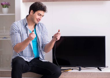 Bozuk televizyonu tamir etmeye çalışan adam