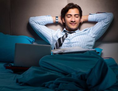 Yorgun işadamı gece fazla mesai yapıyor.