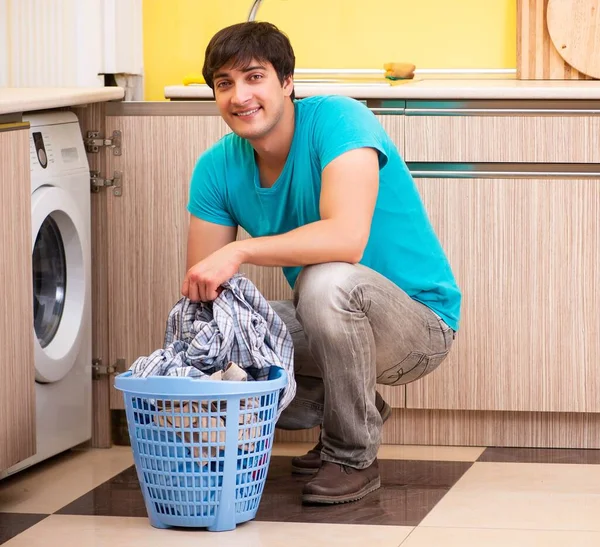 Young husband man doing laundry at home