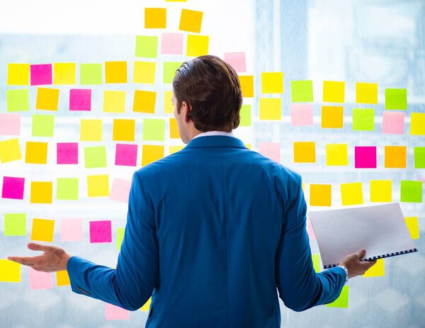 Young handsome employee with many conflicting priorities