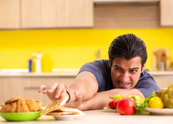 Man having hard choice between healthy and unhealthy food — Stock Photo, Image