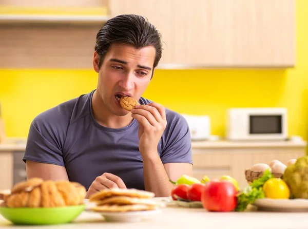 Человек, имеющий трудный выбор между здоровой и нездоровой пищи — стоковое фото