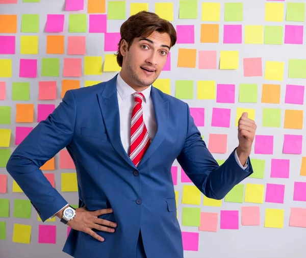 Junger schöner Mann in widersprüchlichem Prioritätenkonzept — Stockfoto