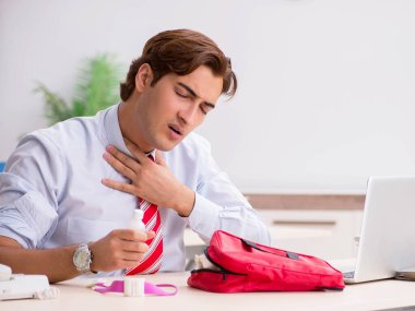 Ofiste ilk yardım çantası olan bir adam var.