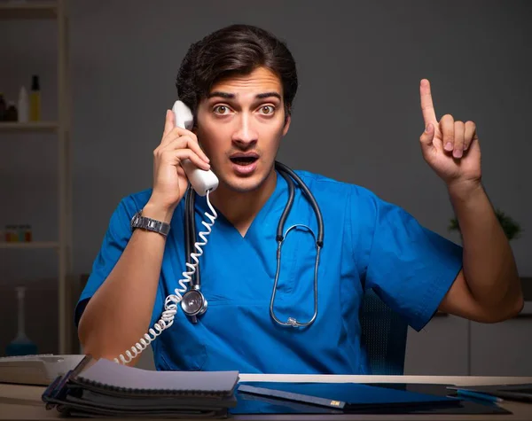 Joven médico guapo trabajando turno de noche en el hospital — Foto de Stock