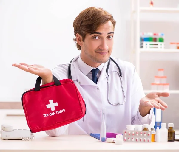 Jovem médico com kit de primeiros socorros no hospital — Fotografia de Stock