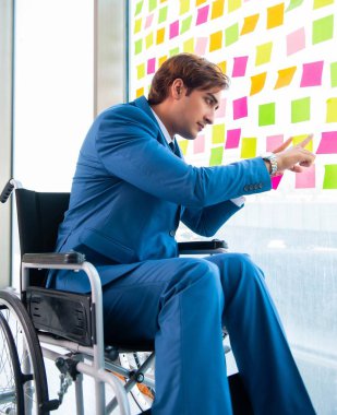 Birçok çelişkili önceliği olan tekerlekli sandalyedeki genç yakışıklı adam.