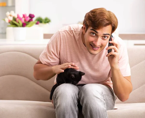 Ung man leker med kattungen hemma — Stockfoto