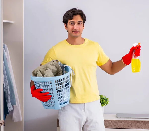 Jovem homem bonito limpeza no quarto — Fotografia de Stock