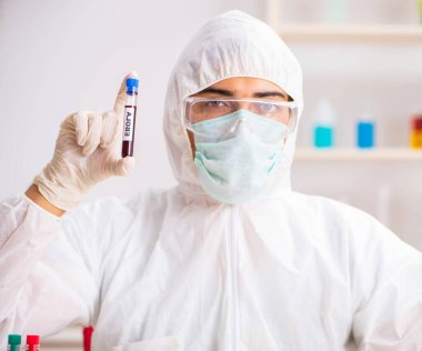 Genç yakışıklı laboratuvar asistanı hastanede kan örnekleri test ediyor.