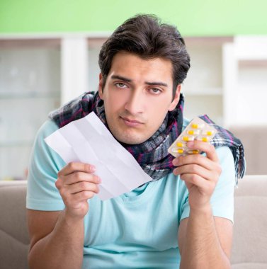 Evde hastalıktan muzdarip genç yakışıklı bir adam.