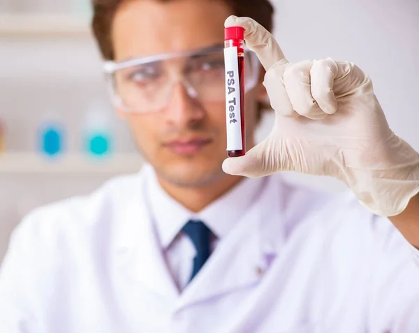 Asistente de laboratorio joven guapo analizando muestras de sangre en el hospital — Foto de Stock