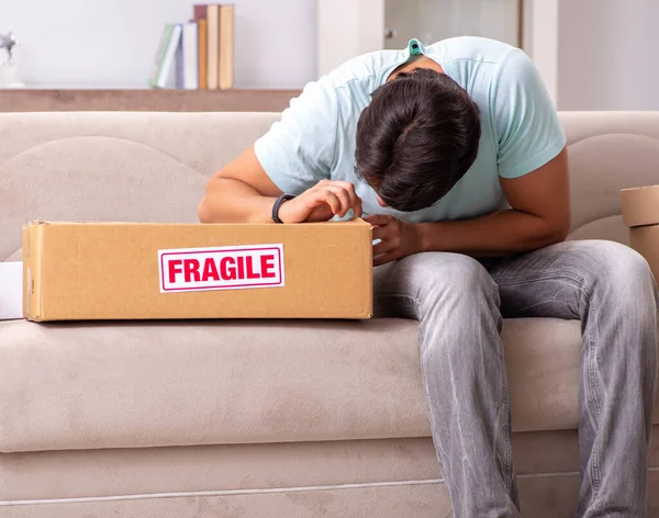 Hombre abriendo frágil paquete ordenado de internet —  Fotos de Stock