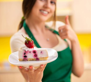 Genç aşçı mutfakta kek pişiriyor.