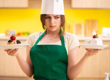 Genç aşçı mutfakta kek pişiriyor.