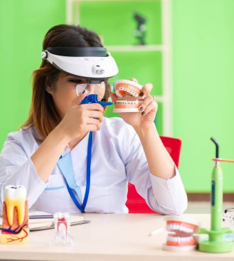 Diş implantı üzerinde çalışan kadın dişçi.