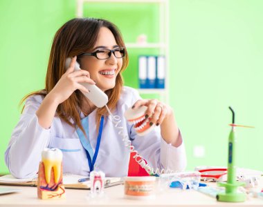 Diş implantı üzerinde çalışan kadın dişçi.