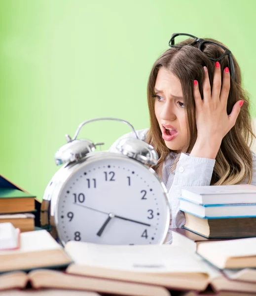 Jonge vrouwelijke student bereidt zich voor op examens met veel boeken in de tijd — Stockfoto