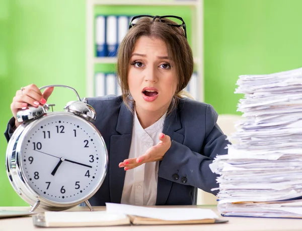 Jonge vrouwelijke werknemer zeer druk met lopende papierwerk in de tijd m — Stockfoto