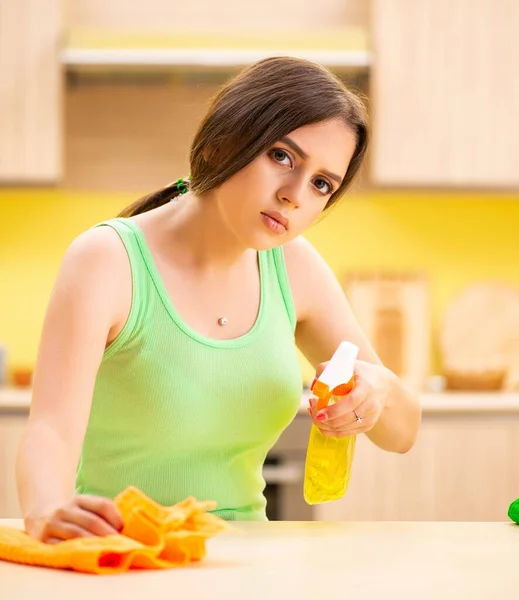 Jovem mulher beatifull polimento mesa na cozinha — Fotografia de Stock