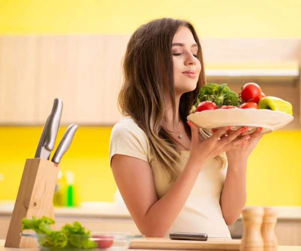 Junge Frau bereitet Salat zu Hause in Küche zu — Stockfoto