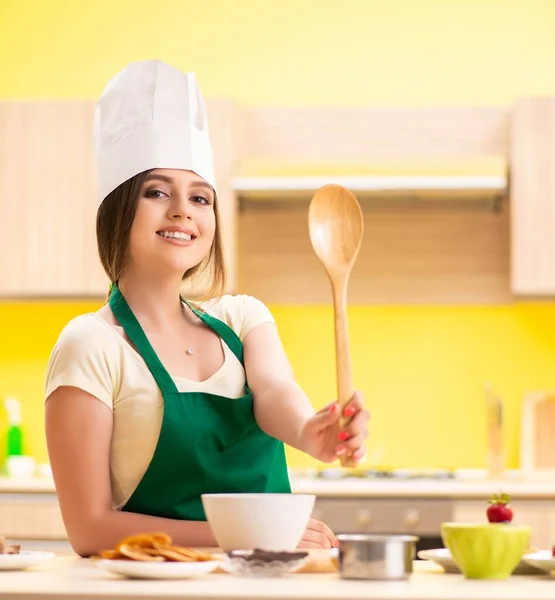 Молодая женщина готовит салат дома на кухне — стоковое фото