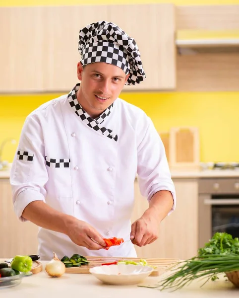 Jeune cuisinier professionnel préparant la salade à la cuisine — Photo